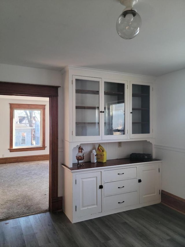 bar featuring white cabinets and dark hardwood / wood-style flooring