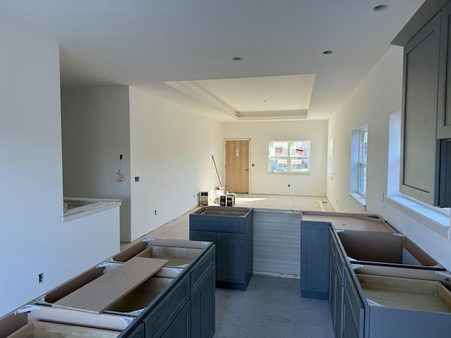 kitchen featuring a tray ceiling, gray cabinetry, and sink