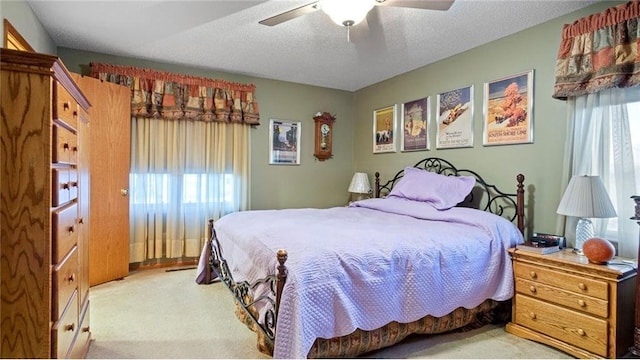 bedroom with light carpet, a textured ceiling, and ceiling fan