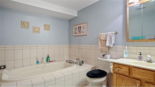 bathroom with vanity, toilet, and tiled tub