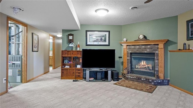 living room featuring a fireplace, light colored carpet, and a textured ceiling