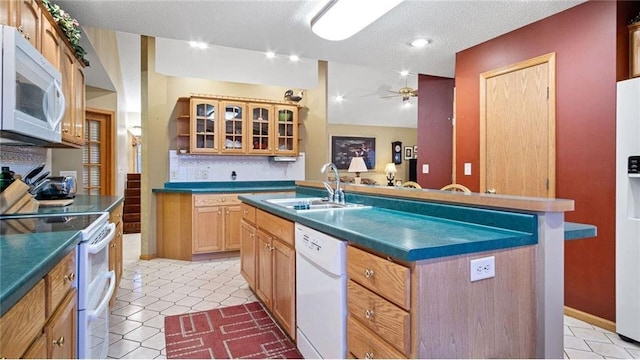 kitchen featuring white appliances, sink, ceiling fan, a textured ceiling, and an island with sink