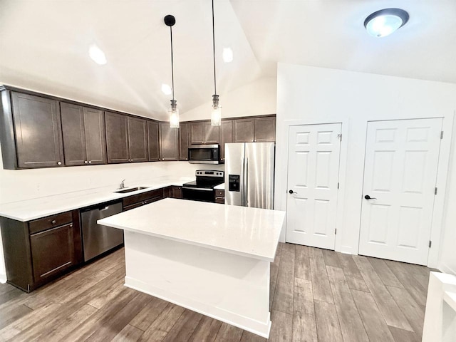 kitchen with dark brown cabinets, stainless steel appliances, a center island, light hardwood / wood-style floors, and hanging light fixtures