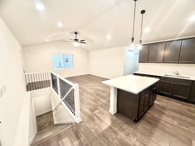 kitchen with a center island, lofted ceiling, sink, hanging light fixtures, and ceiling fan