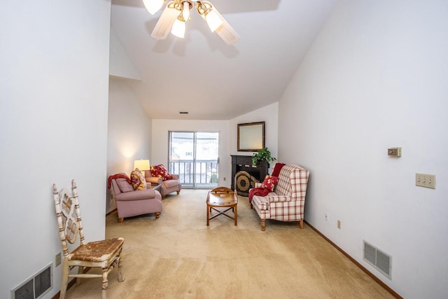 living area with light carpet, ceiling fan, and vaulted ceiling