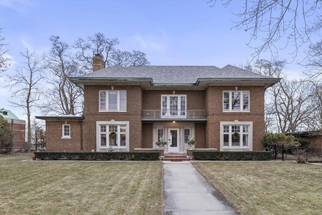 view of front of house with a balcony and a front lawn