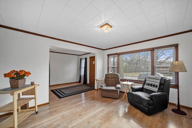 sitting room featuring ornamental molding and light hardwood / wood-style flooring