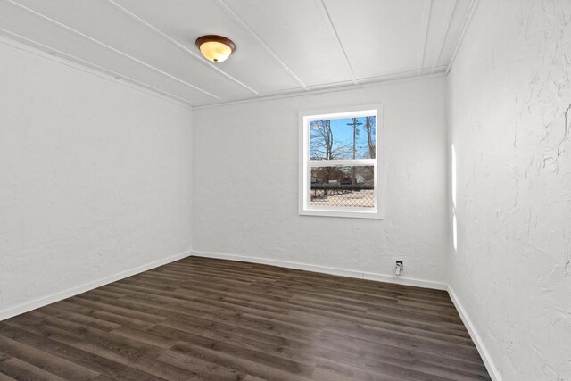 empty room featuring dark hardwood / wood-style floors and crown molding