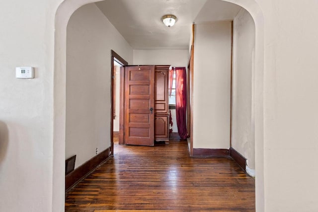 corridor with dark hardwood / wood-style flooring