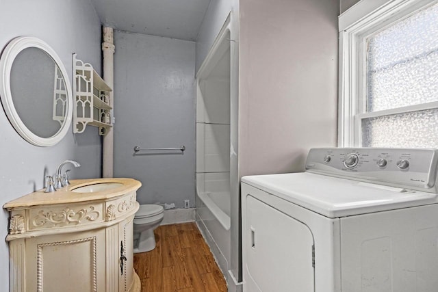 laundry area with hardwood / wood-style floors, washer / clothes dryer, and sink