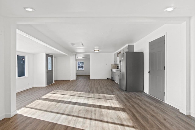 unfurnished living room featuring beamed ceiling and hardwood / wood-style flooring