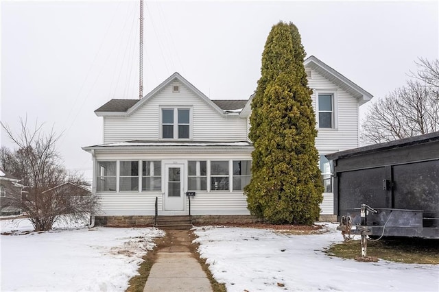 snow covered property featuring a sunroom