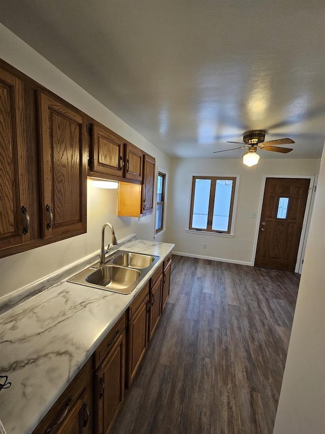 kitchen with ceiling fan, sink, and dark wood-type flooring