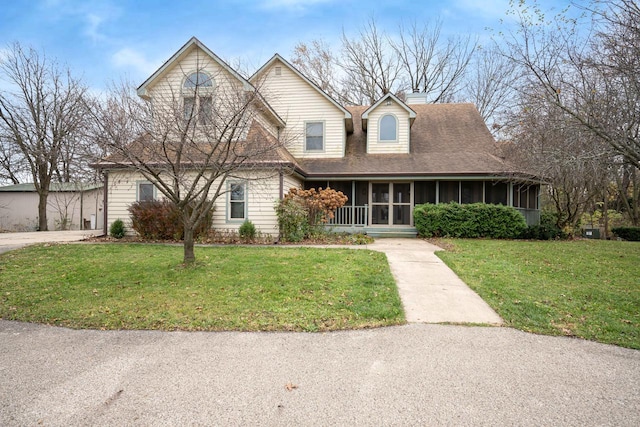 view of front of home with a sunroom and a front yard