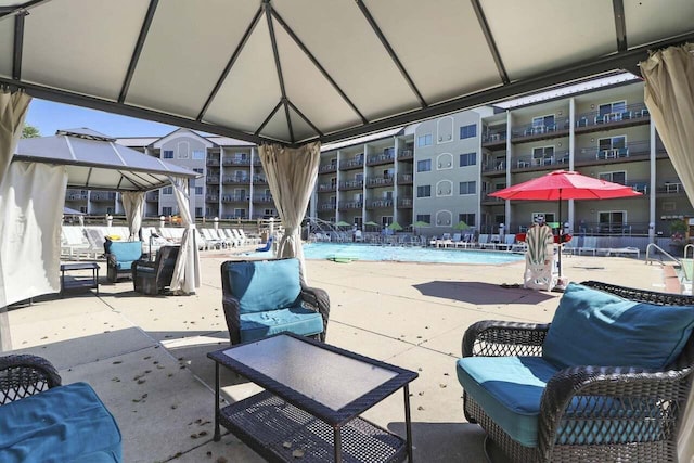 view of patio featuring a gazebo, pool water feature, and a community pool