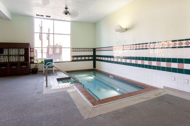 view of swimming pool featuring ceiling fan and an indoor in ground hot tub