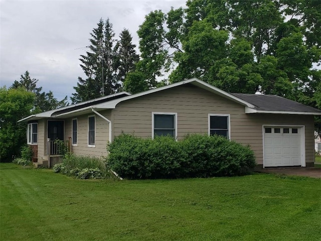 view of side of property with a lawn and a garage