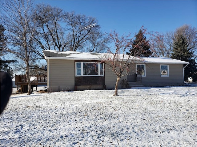 snow covered rear of property featuring a deck