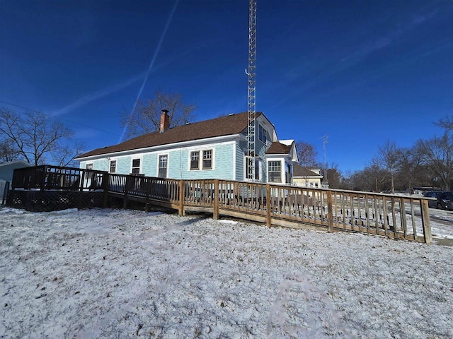 snow covered house featuring a wooden deck