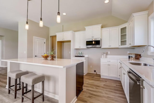 kitchen with white cabinetry, sink, a kitchen island, and appliances with stainless steel finishes