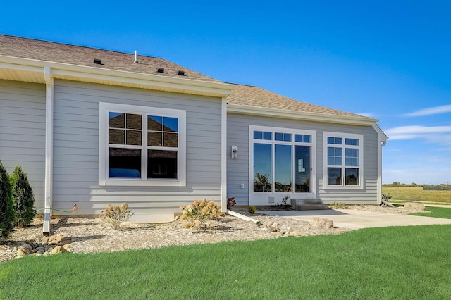 back of house with a patio area and a lawn