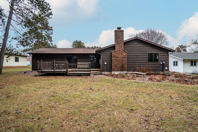 rear view of property with a lawn and a wooden deck