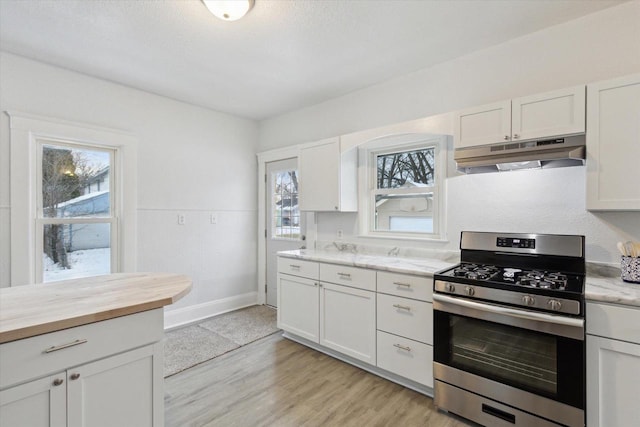 kitchen with gas stove, a wealth of natural light, and white cabinetry