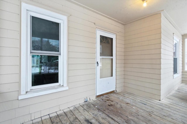 view of exterior entry with a wooden deck