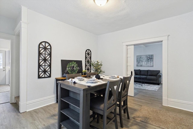 dining area with a textured ceiling and hardwood / wood-style flooring