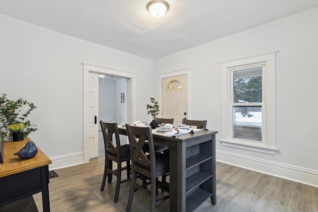 dining space with a textured ceiling and dark wood-type flooring