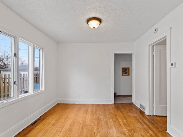 spare room with a textured ceiling and hardwood / wood-style flooring