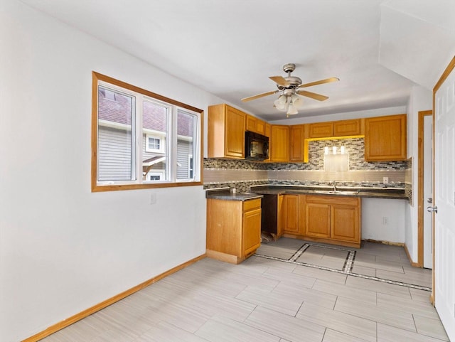 kitchen with backsplash, ceiling fan, and sink