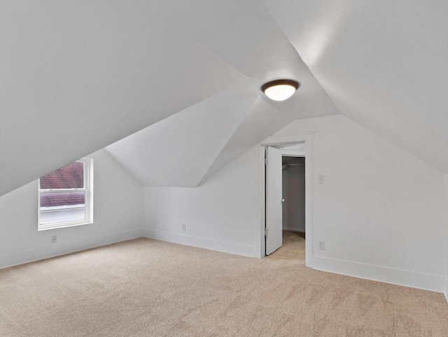 additional living space featuring light carpet and vaulted ceiling