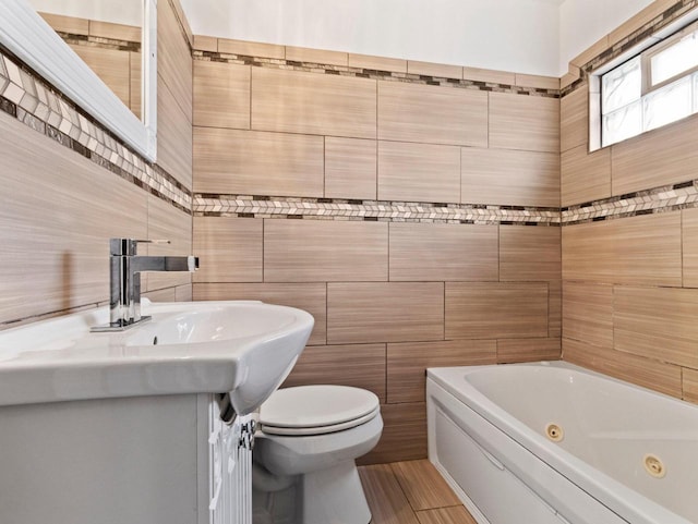 bathroom featuring vanity, toilet, tile walls, and a tub