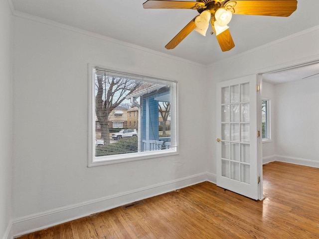 spare room with ornamental molding, a healthy amount of sunlight, and wood-type flooring