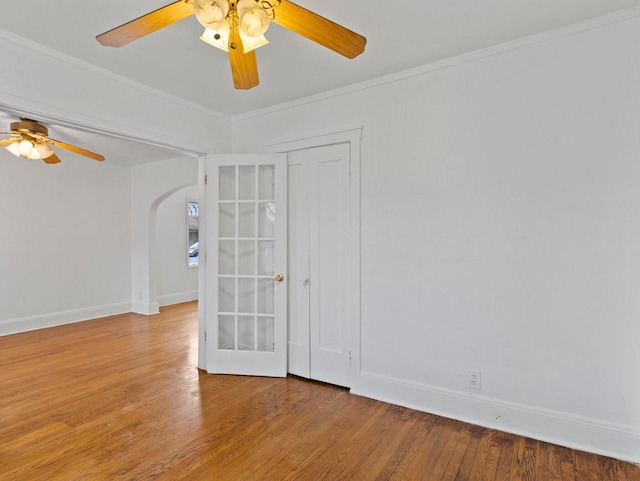 empty room with crown molding, ceiling fan, and wood-type flooring