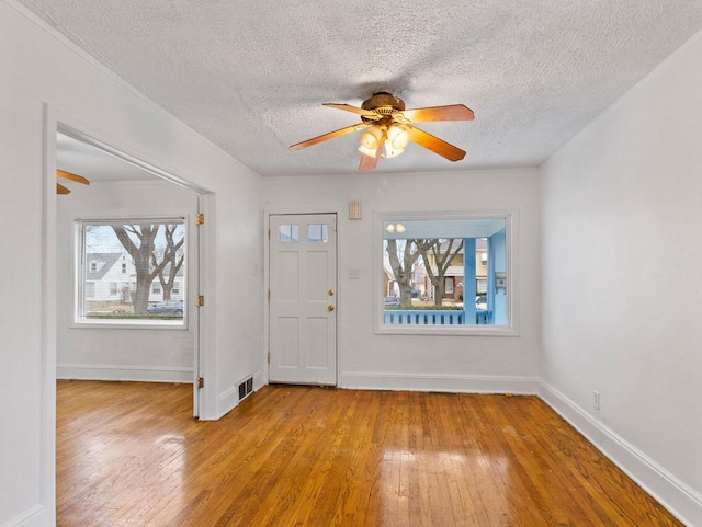 entryway featuring a textured ceiling, light hardwood / wood-style flooring, and ceiling fan