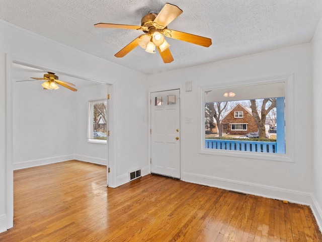 entryway featuring a textured ceiling, light hardwood / wood-style floors, and ceiling fan