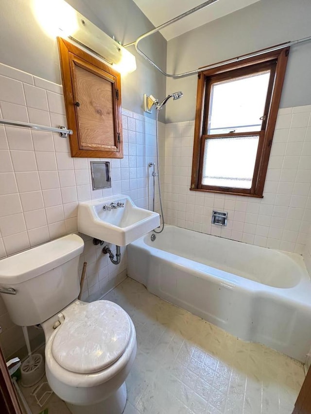 full bathroom with sink, toilet, tile walls, and tiled shower / bath