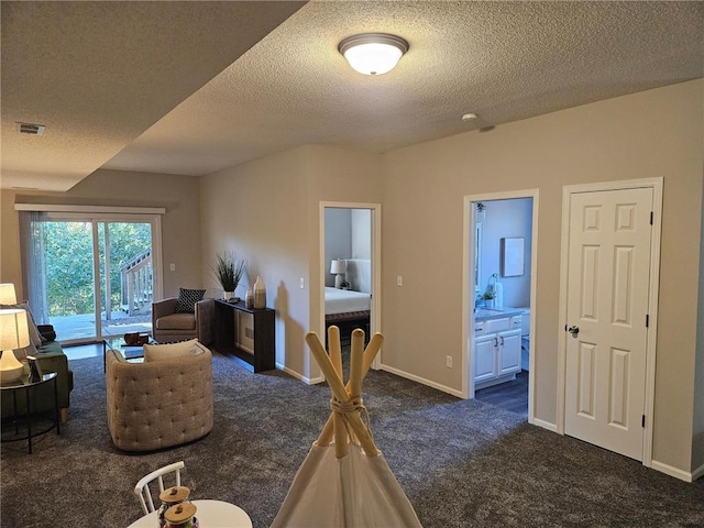 living room with a textured ceiling and dark colored carpet