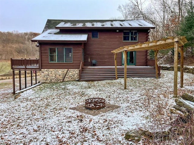 snow covered property with a pergola and a deck