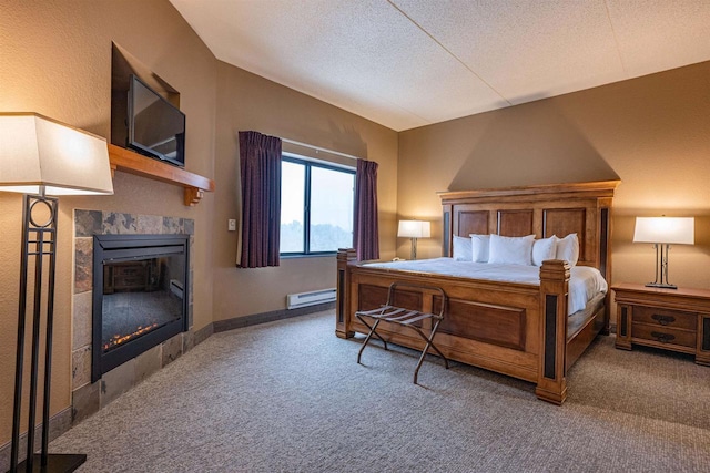 bedroom featuring carpet flooring, a textured ceiling, baseboard heating, and a fireplace