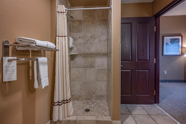 bathroom with a shower with shower curtain and tile patterned flooring