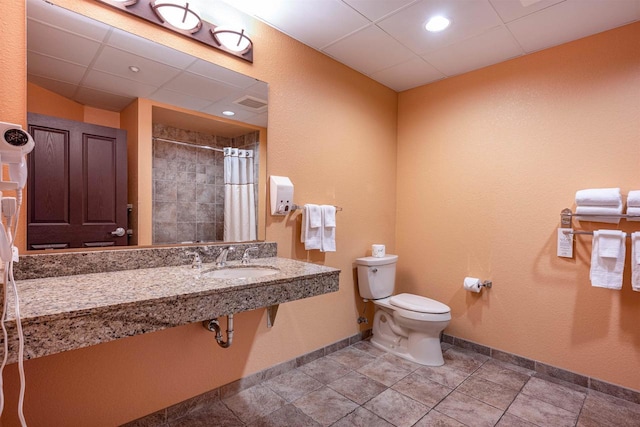 bathroom with walk in shower, sink, and toilet