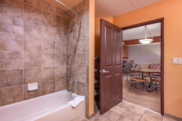 bathroom with tile patterned floors and tiled shower / bath combo