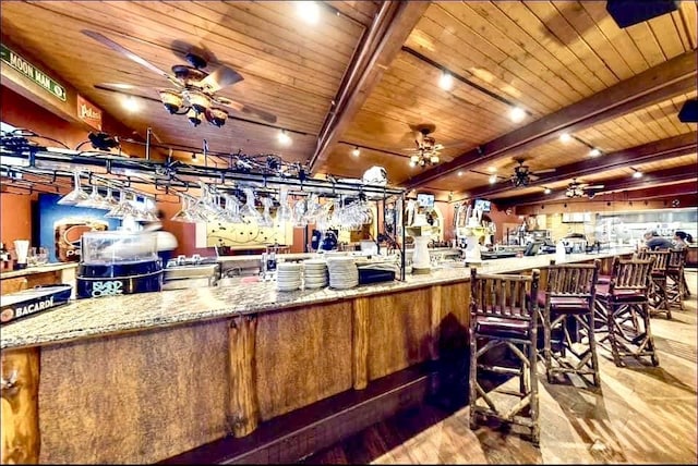 bar featuring beam ceiling, light stone countertops, wooden ceiling, and wood-type flooring