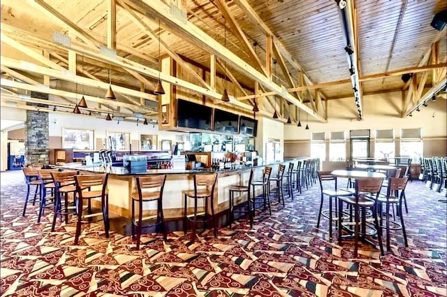 bar with beam ceiling, wooden ceiling, and high vaulted ceiling