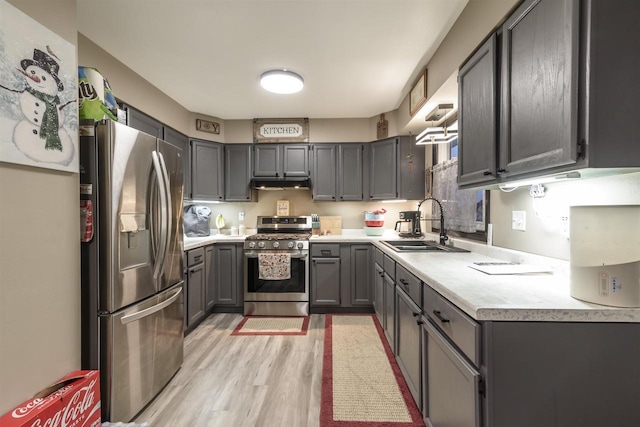 kitchen featuring gray cabinets, sink, light wood-type flooring, and stainless steel appliances