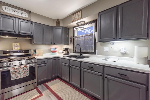 kitchen featuring gray cabinets, sink, light hardwood / wood-style floors, and range with two ovens