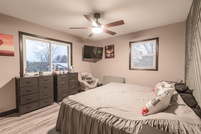 bedroom featuring multiple windows, ceiling fan, and light hardwood / wood-style flooring